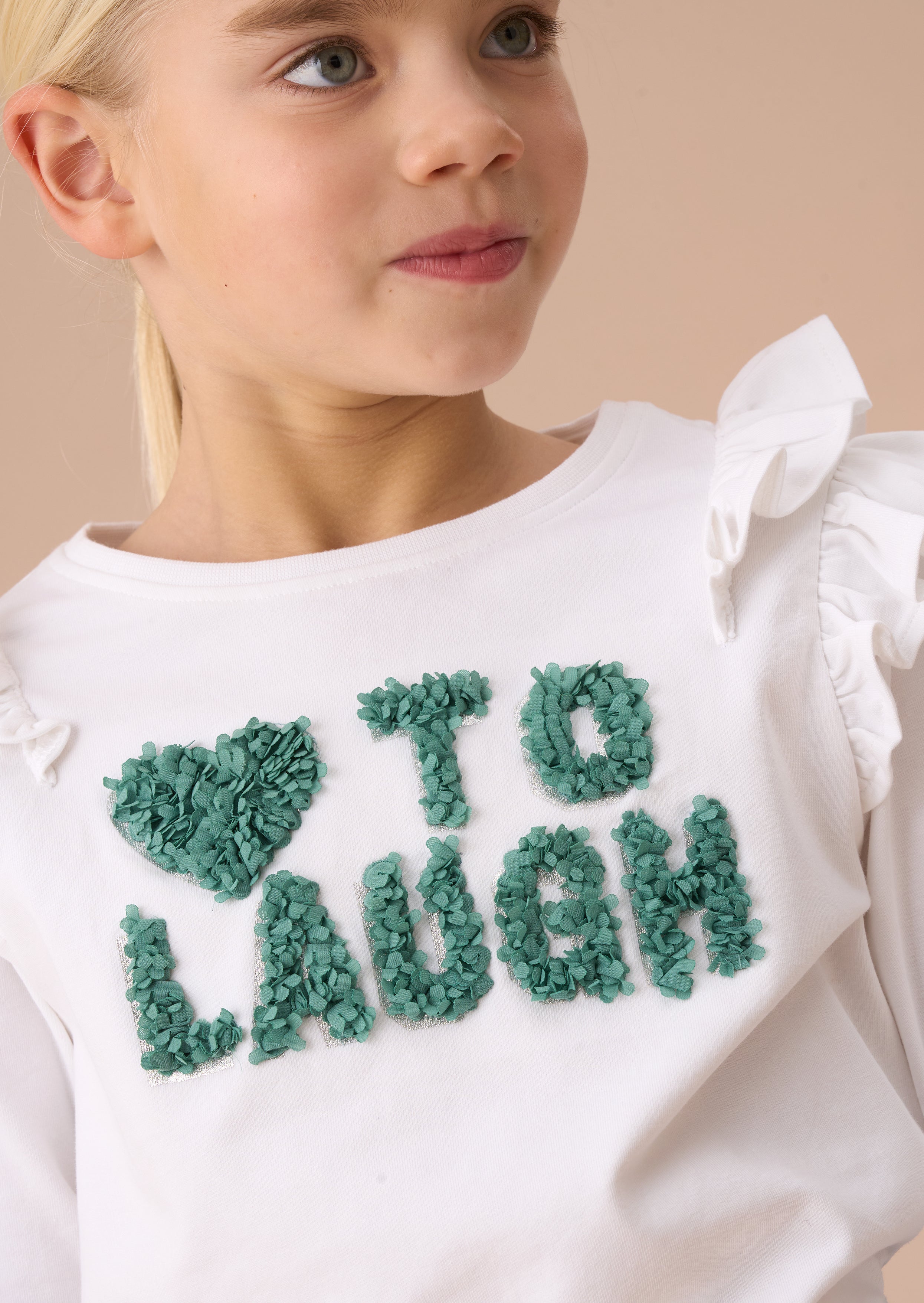 Top bianco Bria a maniche lunghe con volant sulle spalle